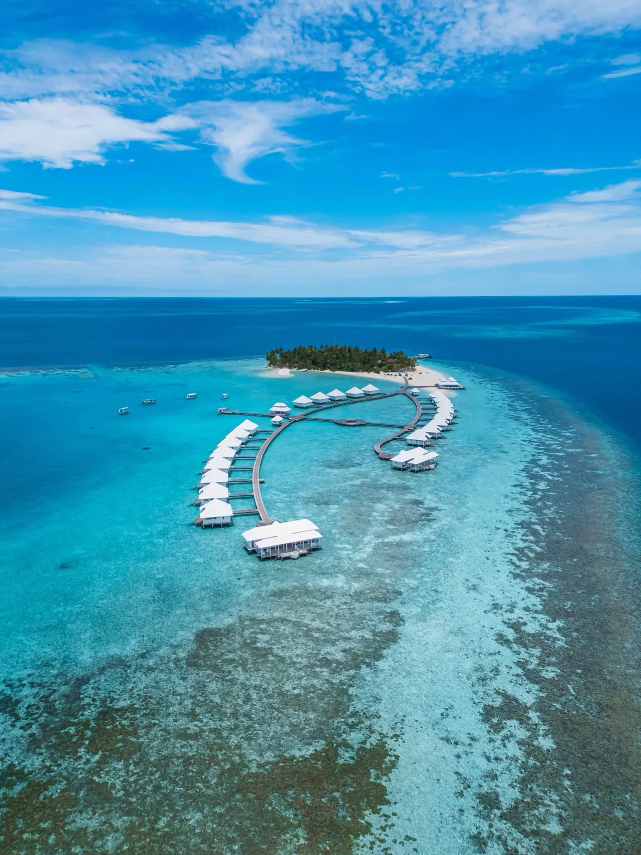 Overwater villas on a curved jetty at Diamonds Athuruga