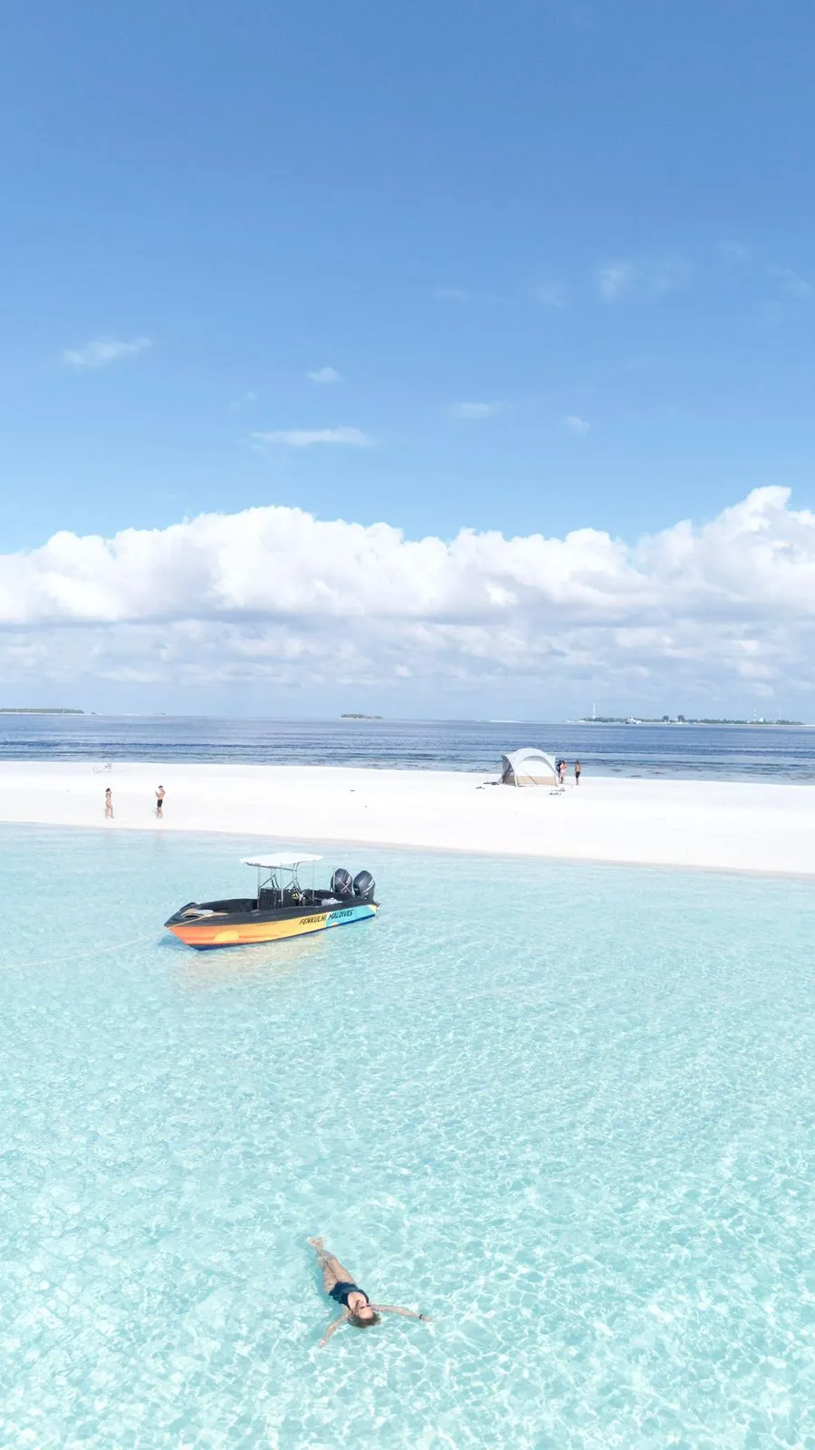 Sandbank and turquoise lagoon with a speedboat in South Ari Atoll, Maldives