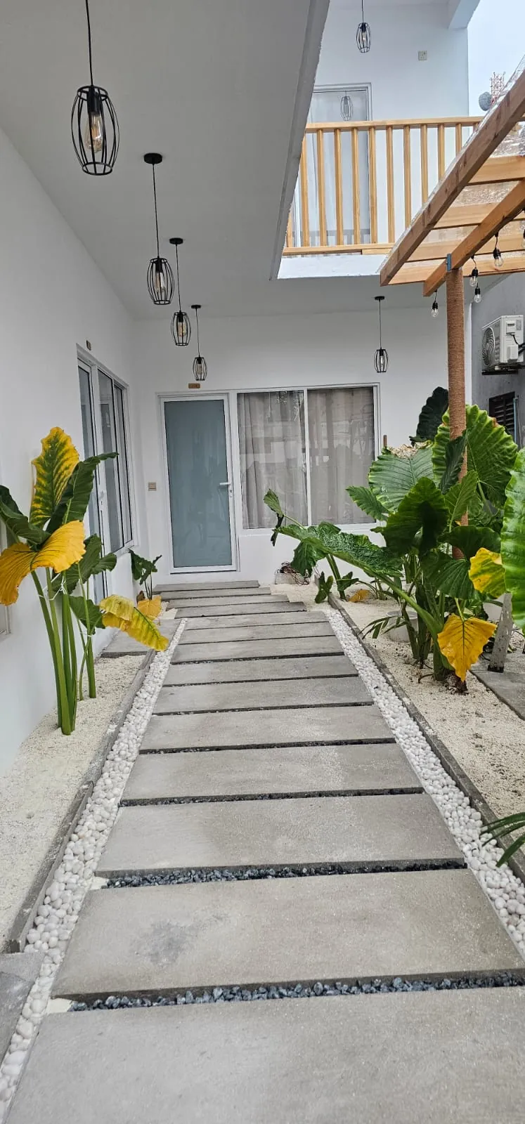 Garden courtyard path beside the guest rooms at Ale Sara Guest House on Thoddoo, Maldives
