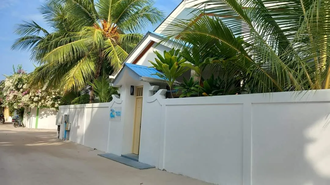 White boundary wall and gate of Ale Sara Guest House on Thoddoo, Maldives