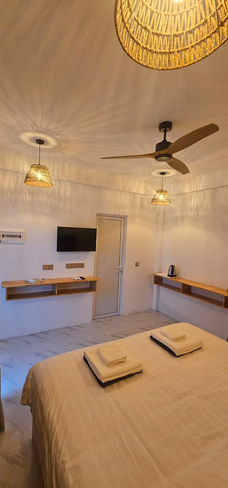 Guest room with woven pendant lamp, TV and ceiling fan at Ale Sara Guest House on Thoddoo, Maldives
