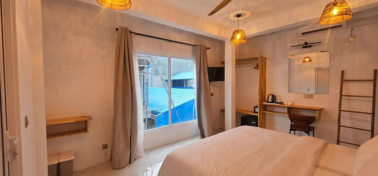 Guest room with double bed, window and desk at Ale Sara Guest House on Thoddoo, Maldives