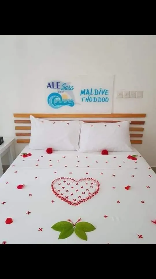 Honeymoon room bed decorated with a rose-petal heart at Ale Sara Guest House on Thoddoo, Maldives