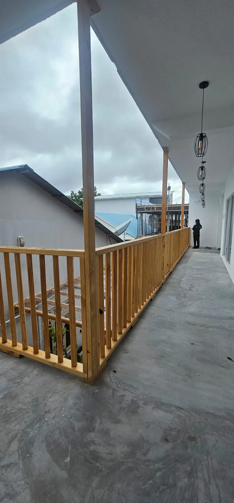 Upper-floor walkway with wooden railing at Ale Sara Guest House on Thoddoo, Maldives