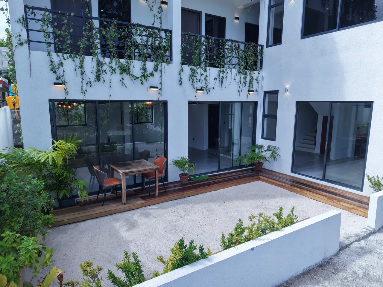 Sand courtyard with dining table and balconies at Cozy Art Dhangethi