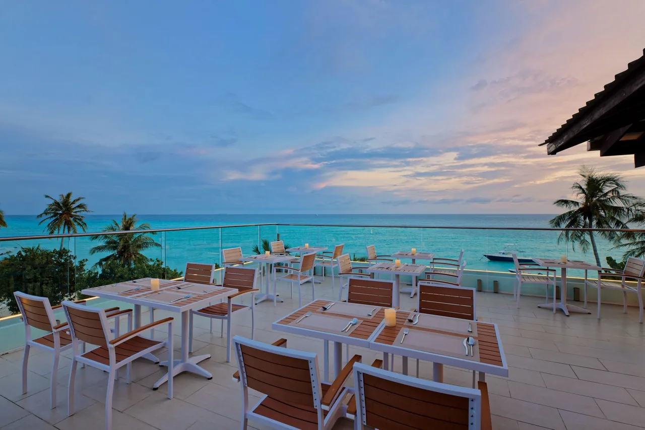 Tables on the rooftop terrace of Luau Restaurant overlooking the sea
