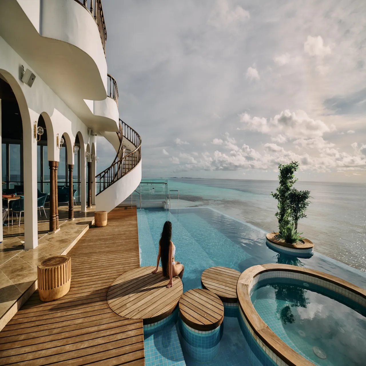 Stone Hotels Dhiffushi building beside its oceanfront pool, Maldives
