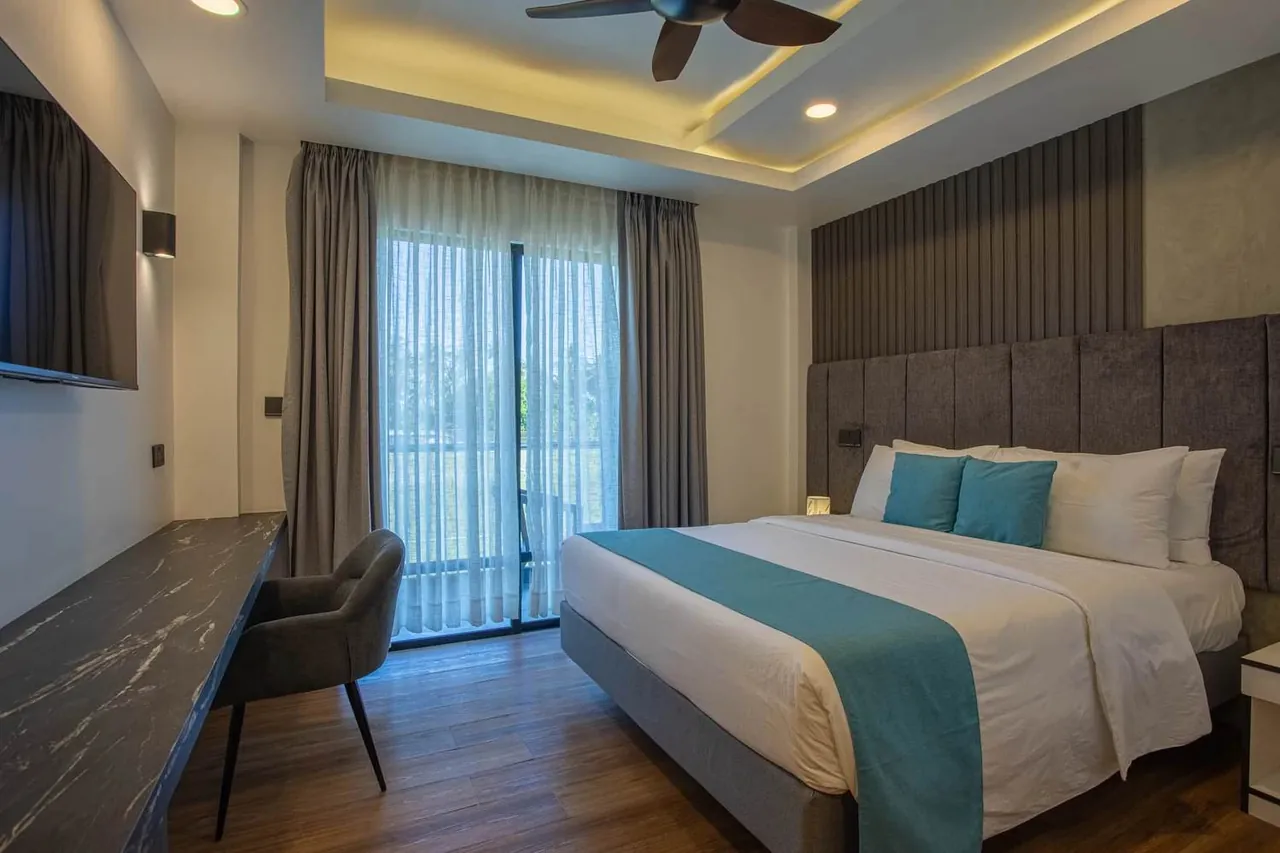Guest room with bed and balcony doors at Whaleshark Beach, Dhigurah
